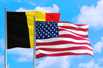 United States and Belgium national flag waving in the windy deep blue sky. Diplomacy and international relations concept.