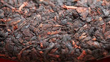Chinese extruded aged pancake-shaped Puer tea, macro picture with blurred background. 