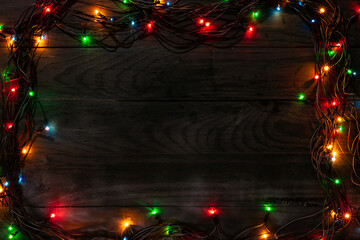 Christmas wooden board black background garland  top view copyspace frame