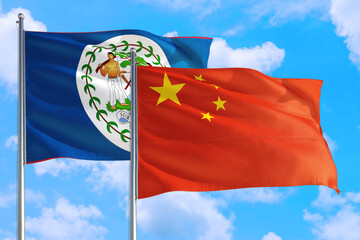 China and Belize national flag waving in the windy deep blue sky. Diplomacy and international relations concept.