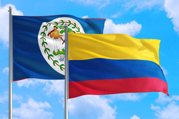 Colombia and Belize national flag waving in the windy deep blue sky. Diplomacy and international relations concept.