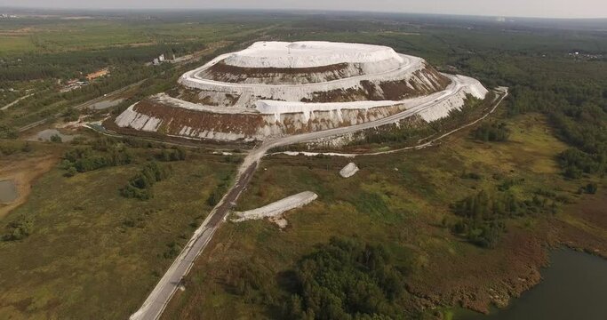 4K sunny morning aerial video of huge industrial phosphorite powder man made "White Mountain" near small town Voskresensk in Moscow Oblast near Moscow, Russia. Phosphorite is still mined there