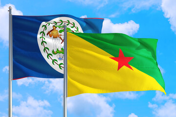 French Guiana and Belize national flag waving in the windy deep blue sky. Diplomacy and international relations concept.