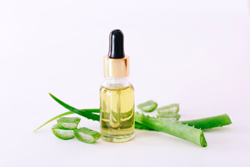 Bottle of aloe vera essential oil with aloe leaves - beauty treatment