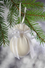 Christmas ball wrapped in a medical mask with a white ribbon.