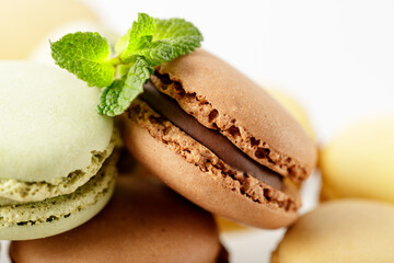 Chocolate macaroon closeup with mint leaves. Stacked assorted  french cookies