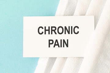 Word chronic pain with medical mask on a blue background.