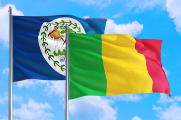 Mali and Belize national flag waving in the windy deep blue sky. Diplomacy and international relations concept.