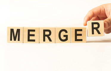 Word merger. Wooden small cubes with letters isolated on white background with copy space...