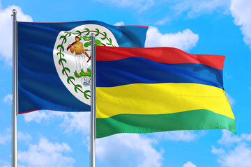 Mauritius and Belize national flag waving in the windy deep blue sky. Diplomacy and international relations concept.