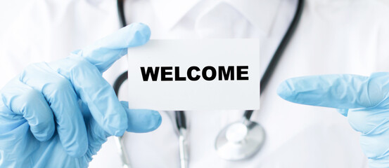 Doctor holding a card with text welcome, Medical concept