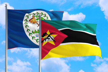 Mozambique and Belize national flag waving in the windy deep blue sky. Diplomacy and international...