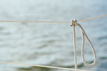 Knot on the fence of the yacht board against the background of the ocean sea water