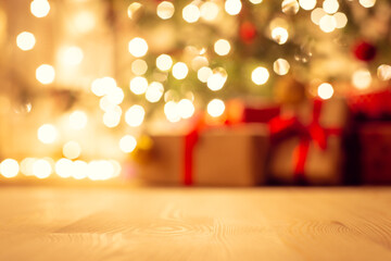 Blurred view of christmas tree in bright warm lights and beautiful presents under it, focus on the...