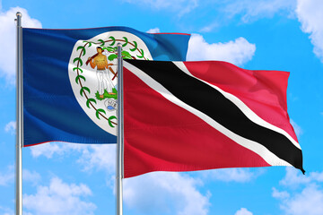 Trinidad And Tobago and Belize national flag waving in the windy deep blue sky. Diplomacy and international relations concept.