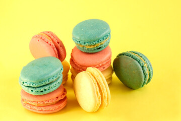 French multicolored sweet pasta cookies on a yellow background.