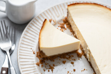 Classical new york cheesecake with slice cut out on a plate. Tasty cheesecake
