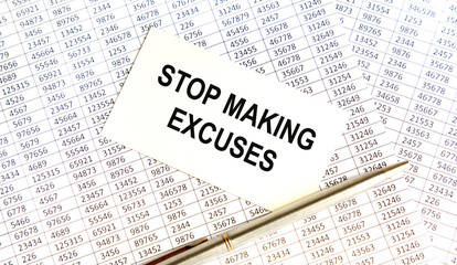 Obraz premium on the business card the text STOP MAKING EXCUSES, next to the pen, the background are reports.