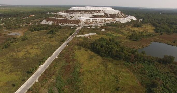 4K sunny morning aerial video of huge industrial phosphorite powder man made "White Mountain" near small town Voskresensk in Moscow Oblast near Moscow, Russia. Phosphorite is still mined there