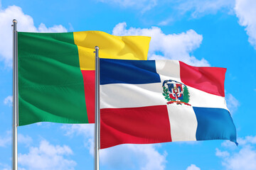 Dominican Republic and Benin national flag waving in the windy deep blue sky. Diplomacy and international relations concept.