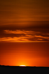 Fototapeta premium PUESTA DE SOL CON CIELO NARANJA ILUMINADO POR EL SOL