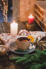 Red hot drink glintwein with spices, cinnamon, anise, fruits, brown sugar on an old wooden table. New Year and Christmas holidays concept. Mulled wine and glintwein.