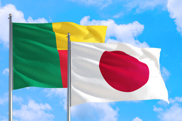 Japan and Benin national flag waving in the windy deep blue sky. Diplomacy and international relations concept.