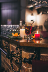 Red hot drink glintwein with spices, cinnamon, anise, fruits, brown sugar on an old wooden table. New Year and Christmas holidays concept. Mulled wine and glintwein.