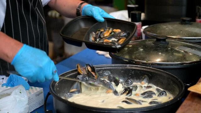 A street food vendor serving Moules Mariniere, Mussels in White Wine Sauce, at a stall in Borough Market, London