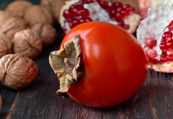 Ripe orange persimmons lie on wooden planks.