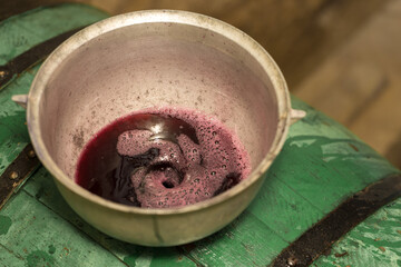 The winemaker pours grape juice for transportation into barrels.