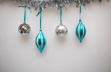 Blue and Silver Christmas Ornaments hanging with a white background.