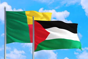 Palestine and Benin national flag waving in the windy deep blue sky. Diplomacy and international relations concept.