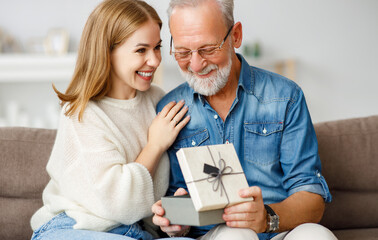 Happy father and daughter examining gift.