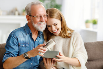 Happy father and daughter examining gift.