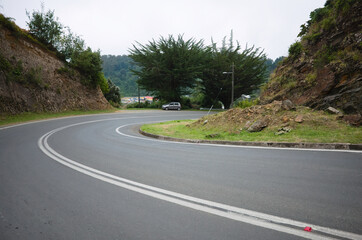 Empty curved road in small village on the Pacific Coast of Chile. Bahia Mansa, Chile.