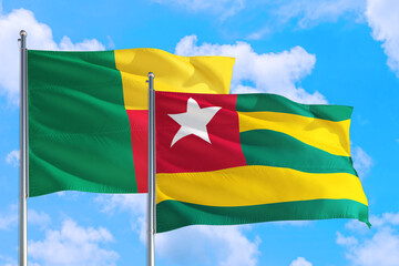 Togo and Benin national flag waving in the windy deep blue sky. Diplomacy and international relations concept.