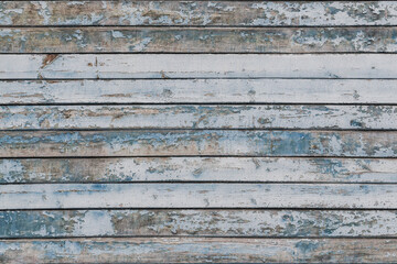 Full frame image of the weathered wooden wall with exfoliated light blue paint. Horizontal texture...