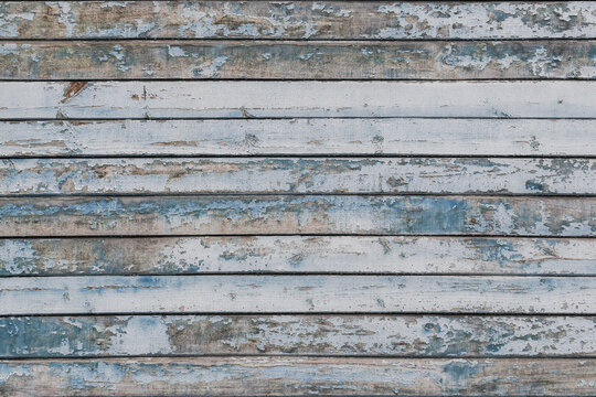 Full frame image of the weathered wooden wall with exfoliated light blue paint. Horizontal texture of old painted wood for wallpaper or background. Empty template for design, copy space