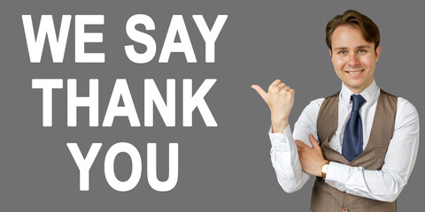 Emotional portrait of businessman showing right hand gesture on text - WE SAY THANK YOU. Gray background.