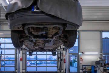  car is on a lifting platform to a car repair shop