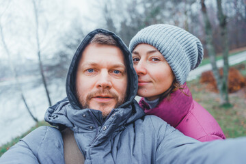 Loving couple makes a selfie in the autumn park.