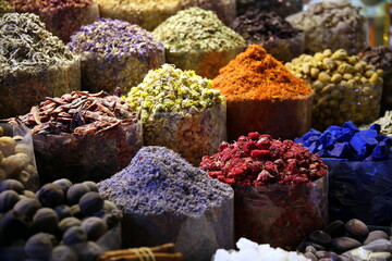 Stall in the Old Souk with containers full of colorful spices (indigo, saffron, turmeric, lavender, walnuts, chilli), Dubai, UAE