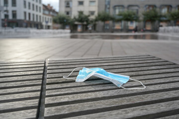 Used surgical face mask against infection with coronavirus and covid-19 carelessly left lying on a...