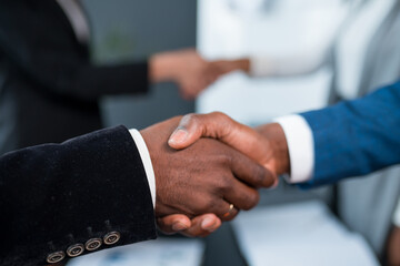 A close-up of two black men shaking hands. Investor and developer two African Americans shake hands.