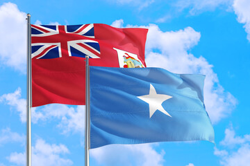 Somalia and Bermuda national flag waving in the windy deep blue sky. Diplomacy and international relations concept.