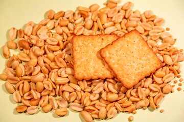 Appetizing brown dry cracker on scattered roasted peanuts
