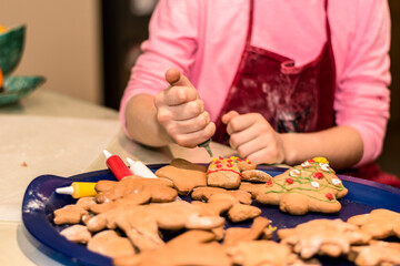 Obraz na płótnie Canvas christmas gingerbread biscuits beeing adorned