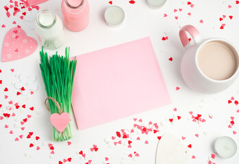 Romantic background with hearts, coffee Cup, pink envelope and a bunch of grass on a light background. Top view with space to copy. In pink tones. Concept of February 14, women's day.
