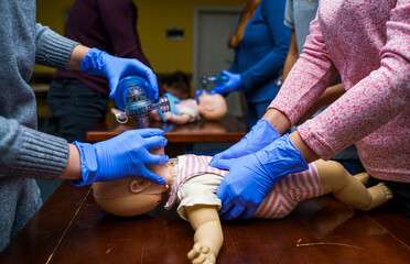 Newborn resuscitation on a infant dummy doll. First help medical class.